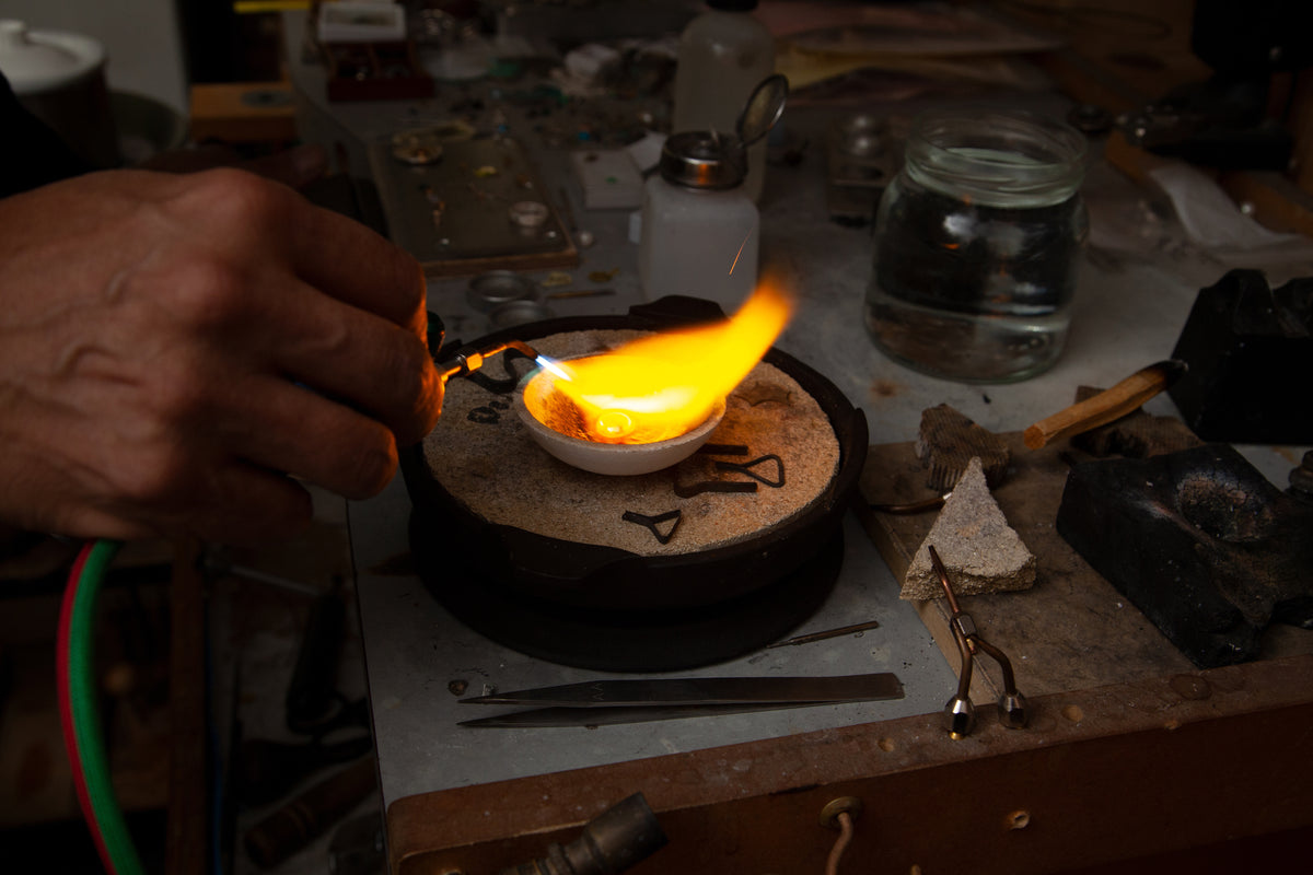our master jeweler is seen creating jewelry by hand and using a flame to melt down metals for this hand made and unique piece.